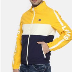 Yellow, White And Navy Blue Full Zip Windbreaker With Packable Hood Brand New With Tags Casual Yellow Track Jacket For Outdoor, Casual Yellow Track Jacket For Fall, Casual Color Block Outerwear For Sports, Casual Color Block Track Jacket For Spring, Yellow Casual Track Jacket For Outdoor, Casual Yellow Long Sleeve Track Jacket, Yellow Functional Windbreaker For Streetwear, Yellow Hooded Sporty Windbreaker, Yellow Long Sleeve Windbreaker For Streetwear