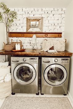 a washer and dryer sitting next to each other in front of a brick wall