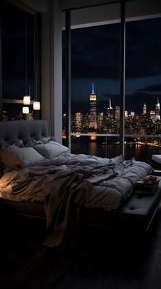 a bedroom with a view of the city at night