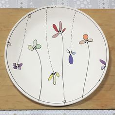 a white plate with dragonflies painted on it