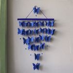 a blue wind chime hanging from the side of a wall