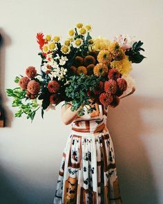 a woman holding a bouquet of flowers in her hands