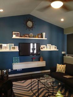 a living room filled with furniture and a flat screen tv on top of a wall