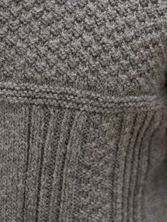 a close up view of the side of a sweater with buttons on it and an open collar