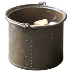 an old metal bucket with a wooden stick sticking out of the top, on a white background