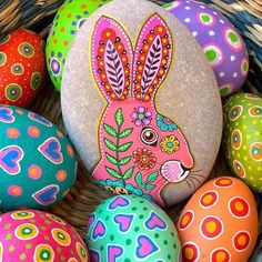 colorful painted eggs in a basket with an image of a rabbit on one side and flowers on the other