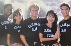 a group of people standing next to each other in front of a wall with the words clean club on it