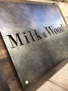 a metal sign that reads milk and wood