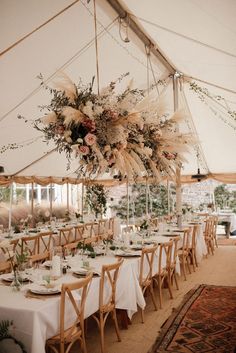 a large tent with tables and chairs set up for a wedding reception in the middle of it