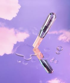 an electric toothbrush floating in the water on a purple and blue background with bubbles