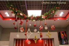 christmas decorations hanging from the ceiling in an office building with red and white striped walls