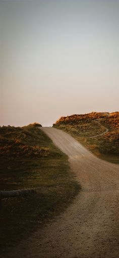 an empty dirt road in the middle of nowhere