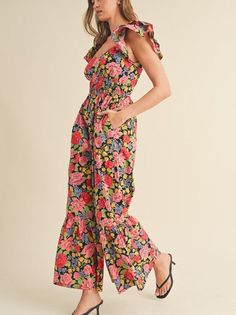 Let your confidence bloom in this flared ruffle hem jumpsuit. Sweetheart neckline and flutter sleeves add a touch of romance, while the tiered elastic waist panel accentuates your figure. Smocked back and pockets bring practicality. With a cut-out on the back, this black floral jumpsuit is a charming and functional choice. Color: Black Floral Fabric: 100% Cotton Brand: &Merci Sizes: S-M-L, Regular Sizing. Model is 5' 10.5" 32-24-36 and wears a S Casual Ruffled Jumpsuits And Rompers, Spring Jumpsuits And Rompers With Ruffled Straps, Spring Ruffled Overall Jumpsuits And Rompers, Casual Summer Jumpsuit With Flutter Sleeves, Spring Ruffle Sleeve Jumpsuits And Rompers With Ruffles, Casual Black Jumpsuits And Rompers With Ruffles, Casual Black Jumpsuit With Ruffles, Casual Fitted Jumpsuits And Rompers With Ruffle Hem, Spring Vacation Jumpsuits With Ruffle Hem