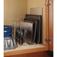 a kitchen cabinet with pots and pans in it