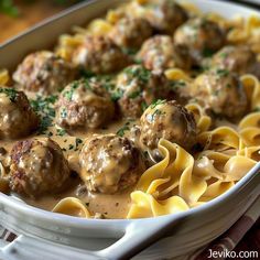 a white dish filled with pasta and meatballs