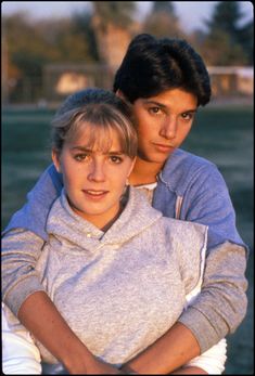 two young women are hugging each other outside