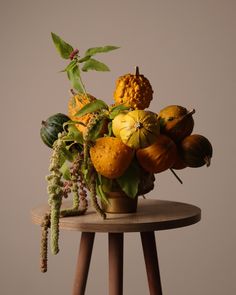 a vase filled with lots of different types of fruit on top of a wooden table