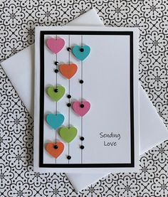 a card with some hearts hanging from it's strings and the words sending love