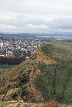 a view of a city from the top of a hill with people walking on it