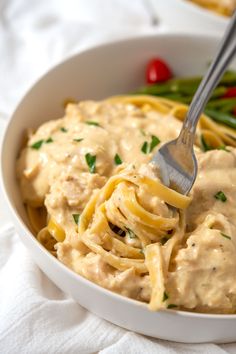 a white bowl filled with pasta and sauce