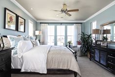 a bedroom with blue walls and white bedding