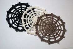 three crocheted coasters sitting next to each other on a white table top