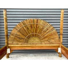 a bed frame made out of bamboo with a sun design on the back and sides