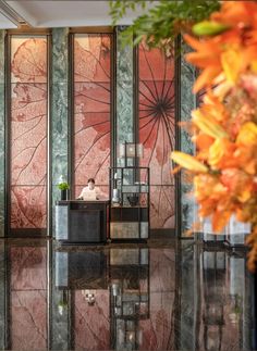 the lobby is decorated with glass panels and flowers