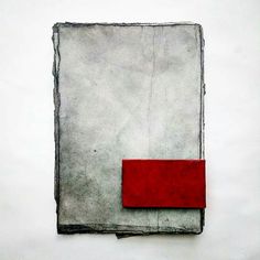 a piece of paper with a red rectangle on top of it in front of a white wall