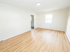 an empty room with hard wood floors and white walls