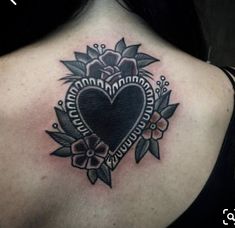 a woman with a heart tattoo on her upper back shoulder and chest, in black and white