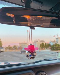 a mirror hanging from the side of a car with a disco ball attached to it