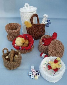 several knitted baskets with stuffed animals and toys in them on a blue tablecloth