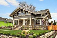 a green house with stone and wood trimmings in the front yard is shown