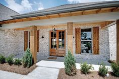 the front entrance to a home with wooden shutters