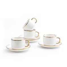 four cups and saucers with gold rims on white background, one is empty