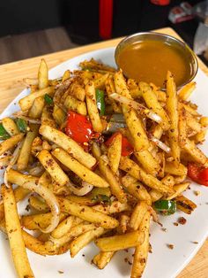 a white plate topped with french fries next to a bowl of ketchup and mustard