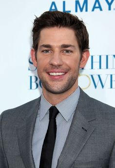 a man in a suit and tie smiling for the camera