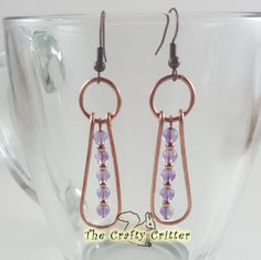 Bright copper and light purple amethysts work so well together!  The amethysts are separated  by small copper beads and surrounded by hammered copper wire.  The group is then held together with a large jump ring.  Hammered metal has such a wonderful texture! The earrings measure approximately 1 ¾" from the top of the weave to the bottom of the earring.  This measurement does not include the ear wires. Colors may appear different than they actually are depending on your monitor color settings and the lighting used during photography. Gemstone Properties: Amethysts are associated with: *Addiction Recovery *Alcoholism Recovery *Awareness *Balance *Communication *Love *Meditation *Relief from Acne *Relief from Anger *Relief from Fear *Well Being *Wisdom Every item I create is made with great c Purple Amethyst Earrings, Wire Jewelery, Wire Wrap Jewelry Designs, Bijoux Fil Aluminium, Gemstone Properties, Earrings Wire, Wrapped Earrings, Earrings Purple, Wire Wrapped Earrings