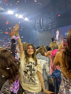 a group of people at a concert with confetti thrown in the air and on their hands