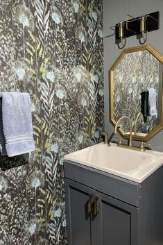 a bathroom with a sink, mirror and towel rack on the wall next to it