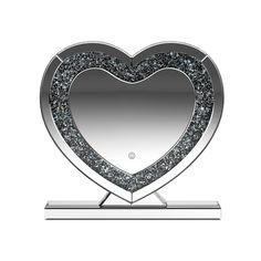 a silver heart shaped mirror on top of a metal stand with a black and white background