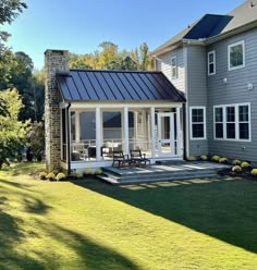 a house with a metal roof and white windows