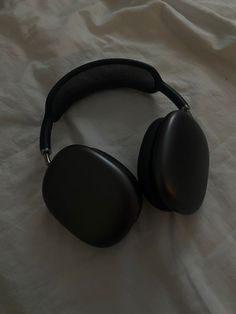 a pair of headphones sitting on top of a white sheet