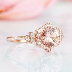 an engagement ring with a pink morganite surrounded by white diamonds on a floral background