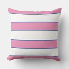 a pink and blue striped pillow on a white wall