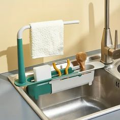 a toothbrush holder in the middle of a stainless steel sink with soap dispenser