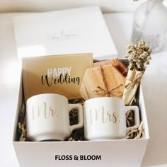 two coffee mugs in a gift box with the words happy wedding written on them