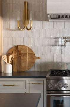 a wooden cutting board sitting on top of a kitchen counter next to a stove and oven