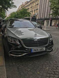 a mercedes s - class parked on the side of a street in paris, france